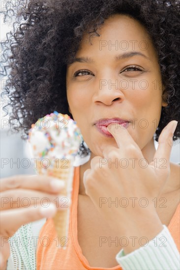 Smiling woman eating ice cream cone
