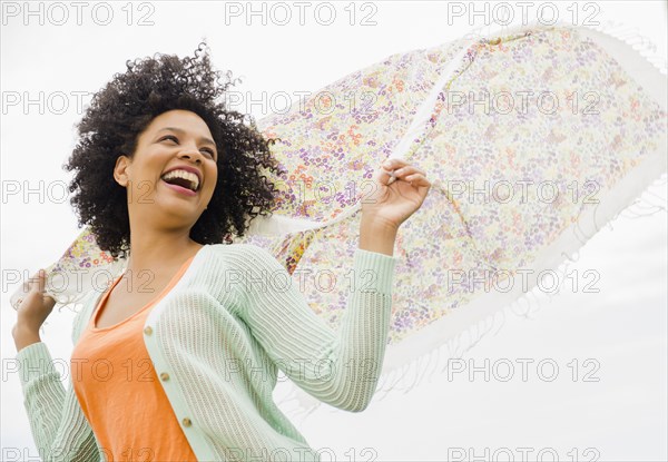 Low angle view of woman playing with scarf outdoors