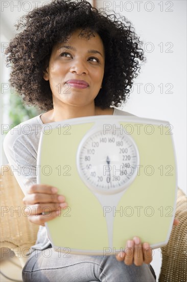 Smiling woman holding scale