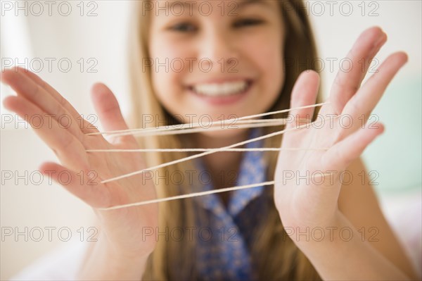 Caucasian girl playing cats cradle game