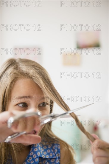 Caucasian girl cutting her own hair