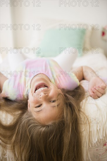 Caucasian girl playing on bed