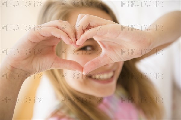 Caucasian girl making heart shape with hands