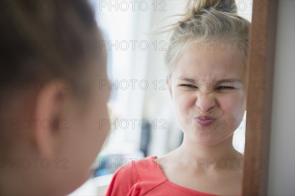 Caucasian girl scrunching up her face in mirror