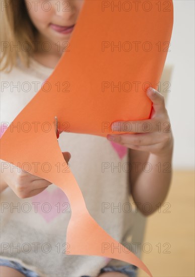 Caucasian girl cutting construction paper