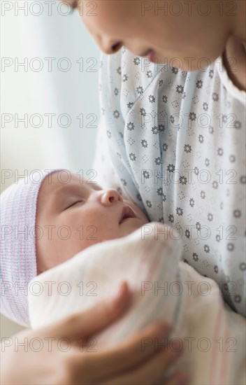 Asian mother holding newborn baby in hospital