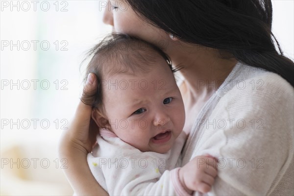 Asian mother comforting crying baby