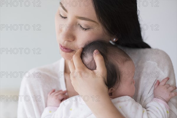 Asian mother hugging baby