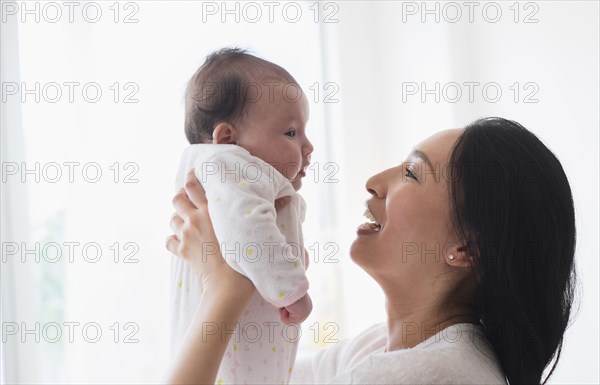 Asian mother playing with baby