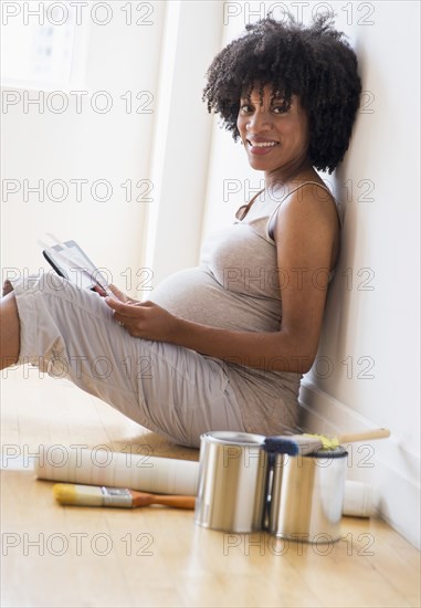 Pregnant African American mother examining paint swatches for nursery