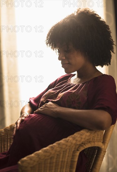 Pregnant African American mother holding her stomach