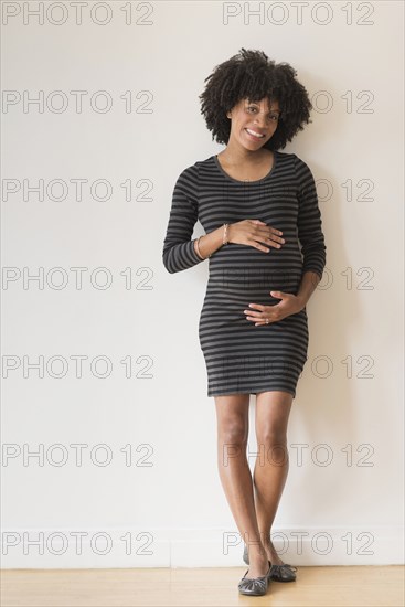 Pregnant African American mother holding her stomach