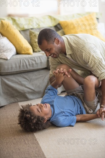 Father and son playing on floor in living room