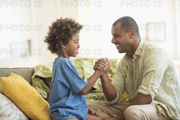 Father and son arm wrestling in living room