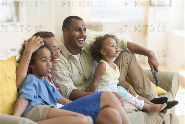 Family watching television together in living room