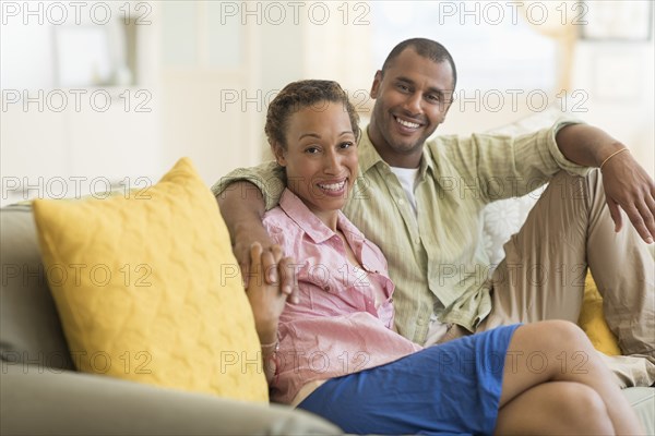 Couple smiling on sofa in living room