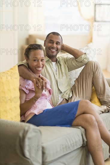 Couple smiling on sofa in living room