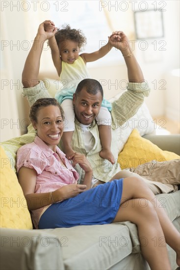 Family smiling on sofa in living room