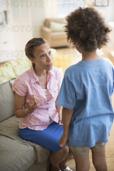 Mother talking to son in living room