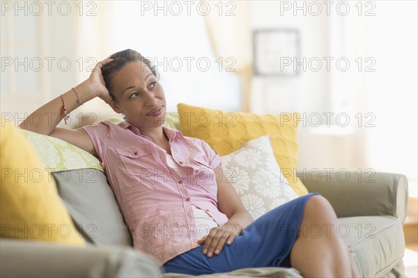 Mixed race woman smiling on sofa