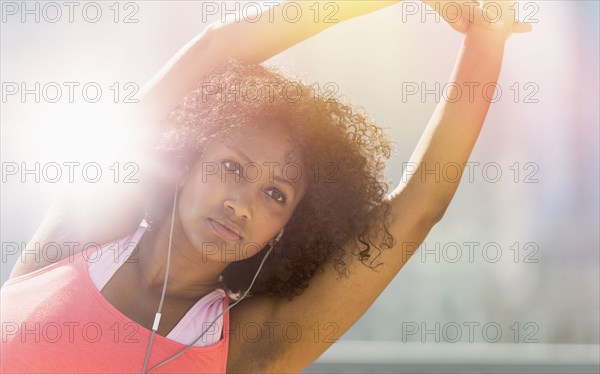 Mixed race woman stretching arms