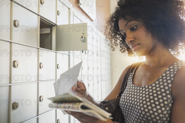 Mixed race businesswoman checking mailbox