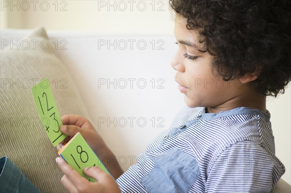 Mixed race boy using flash cards to study math