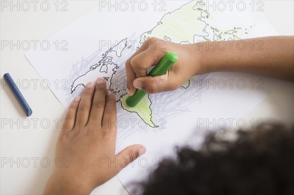 Mixed race boy coloring in world map