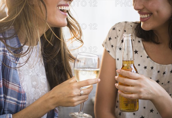 Hispanic women drinking beer and wine together