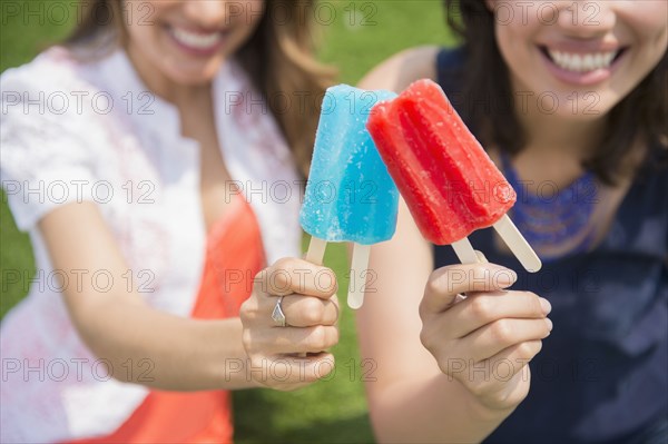 Hispanic women eating popsicles outdoors