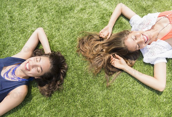 Hispanic women laying in grass outdoors