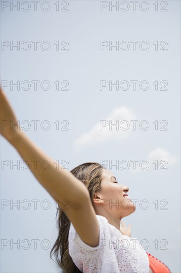 Hispanic woman playing under blue sky