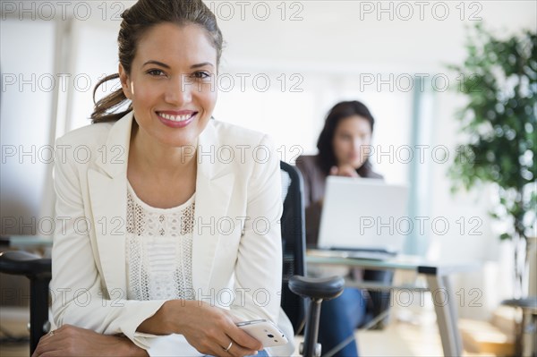 Hispanic businesswoman smiling in office