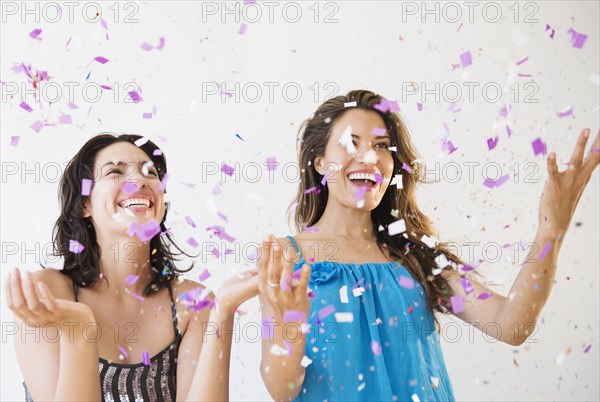 Hispanic women throwing confetti at party
