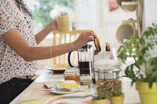 Mixed race woman preparing breakfast in kitchen