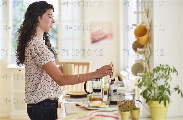 Mixed race woman preparing breakfast in kitchen