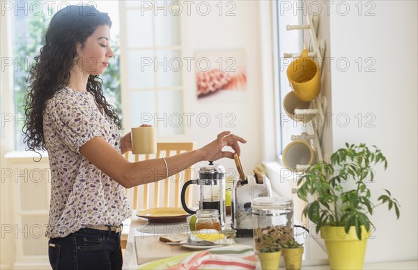 Mixed race woman preparing breakfast in kitchen