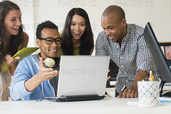 Business people working together on laptop in office