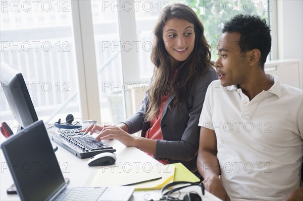 Business people working together on computer in office