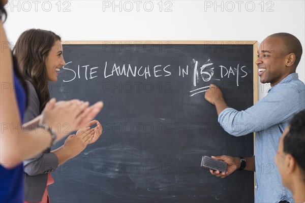 Business people cheering and gearing up for site launch in office