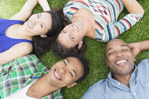 Friends laying in grass outdoors