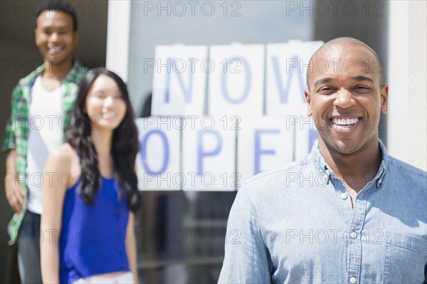 Friends smiling together by newly open storefront