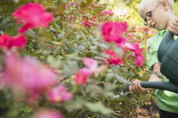 Caucasian boy watering flowers