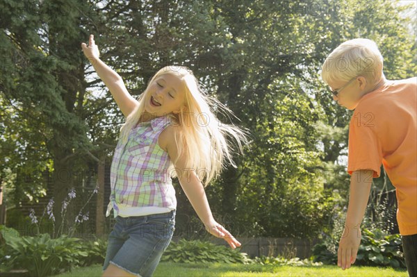 Caucasian children playing in backyard