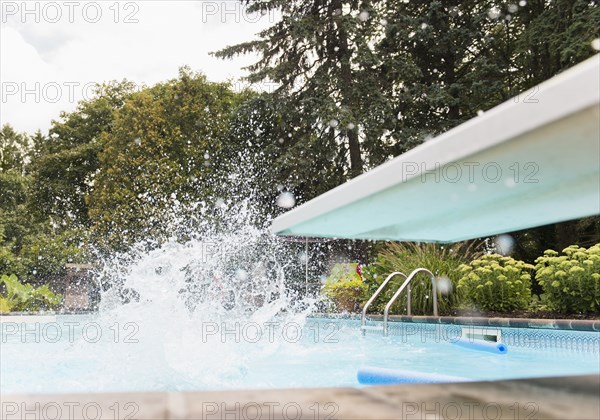 Splashing water near diving board in swimming pool