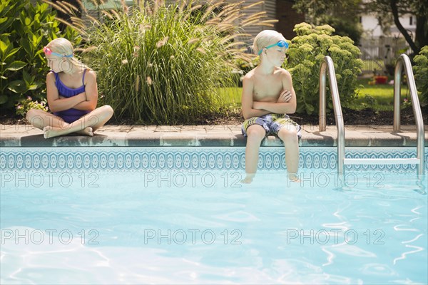 Caucasian children arguing at swimming pool