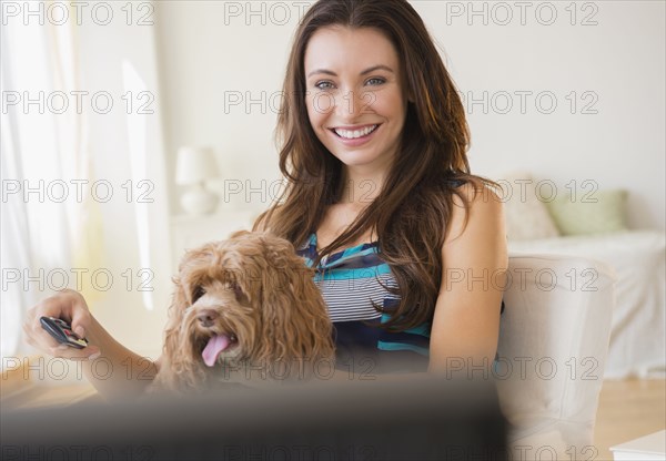 Caucasian woman watching television with pet dog