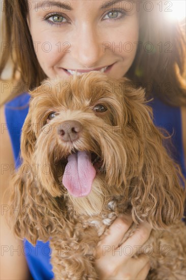 Caucasian woman holding pet dog