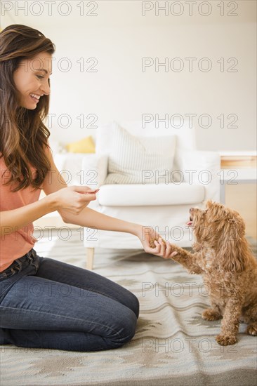 Caucasian woman teaching pet dog to shake