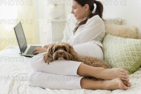 Caucasian woman using laptop with pet dog